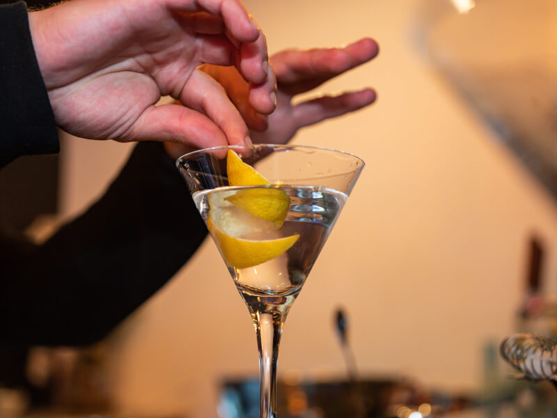 Adding lemon rind to martini cocktail